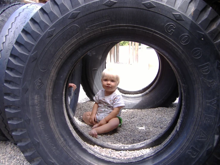 a little  sitting next to a tire