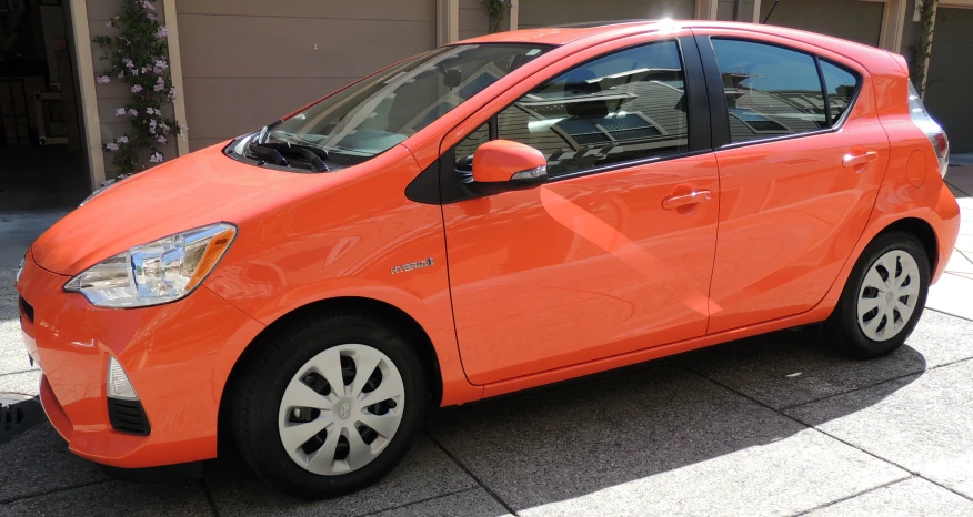 a bright orange car parked outside of a building
