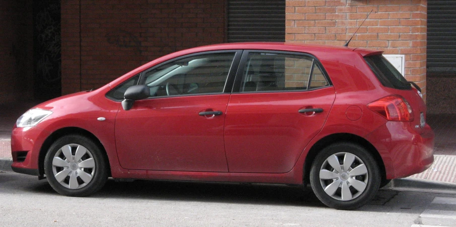 a red car is parked on the street