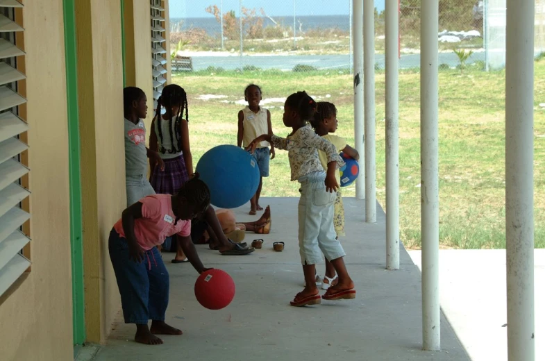 children are playing with balls in a porch
