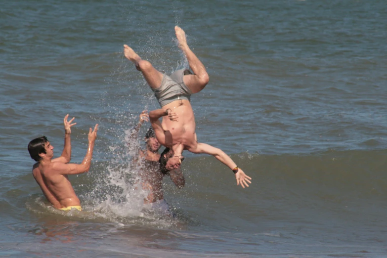 a man falling into water while riding a wave on his back
