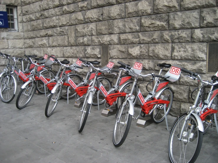 many bicycles are lined up against a brick wall