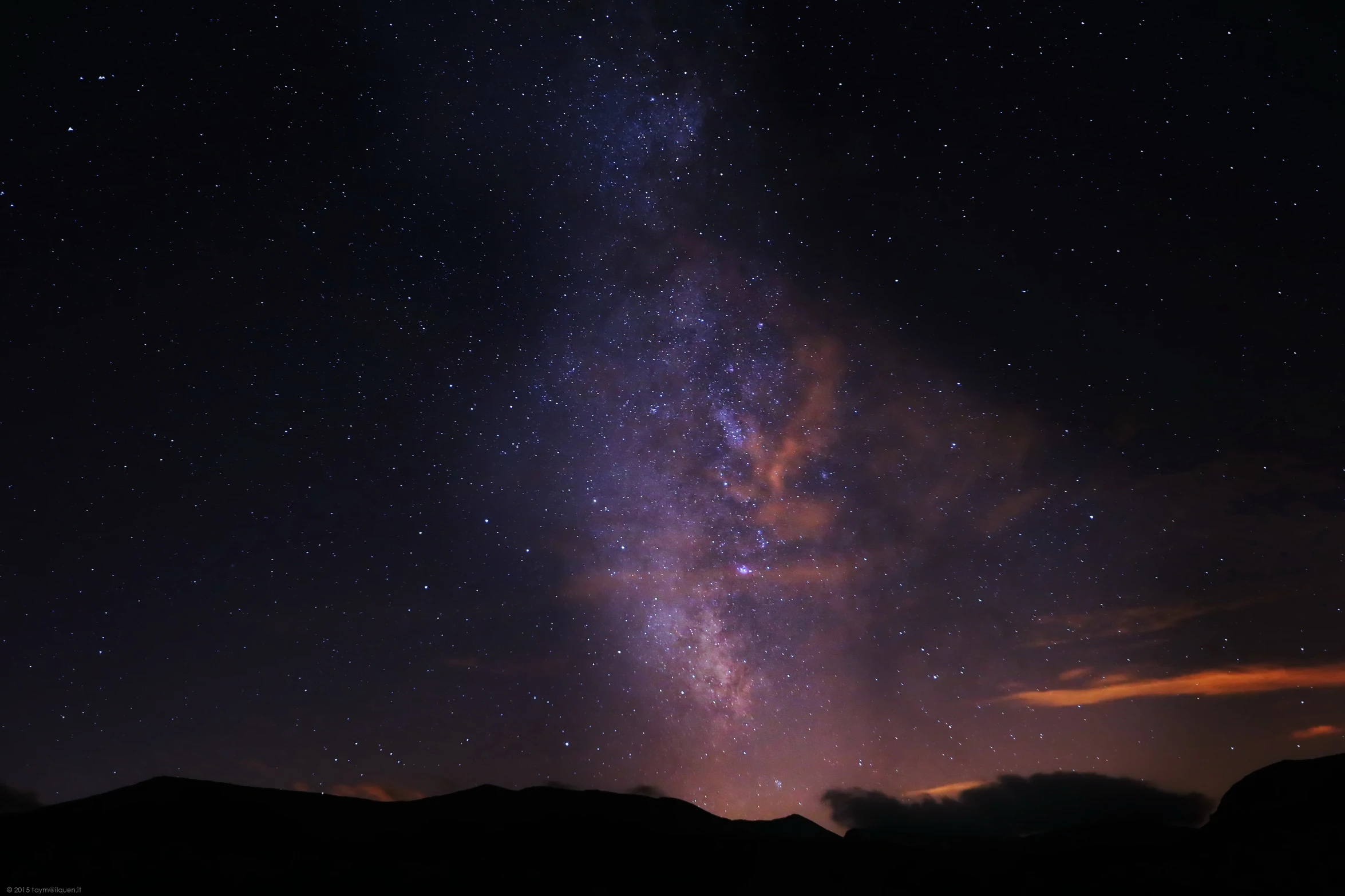 a starr filled sky is captured from the shore