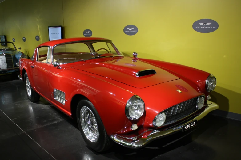 a row of classic cars on display in a museum