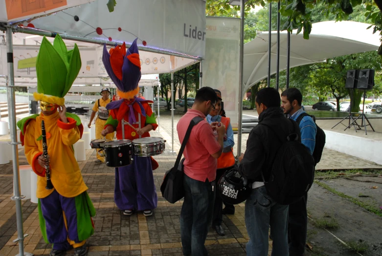 group of people wearing costumes standing under tent