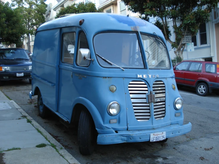 an old blue truck parked next to a building