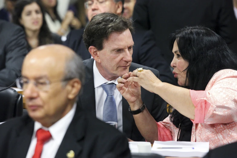 a man helping a woman eat food in a group