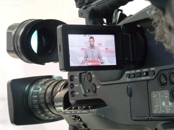 a black video camera next to an empty lens and a white background