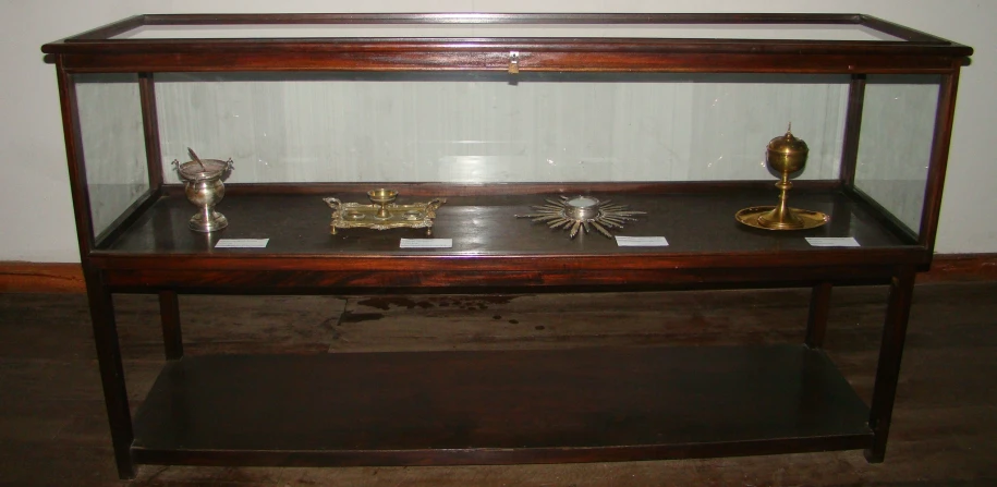 a glass display case with candles and other decor