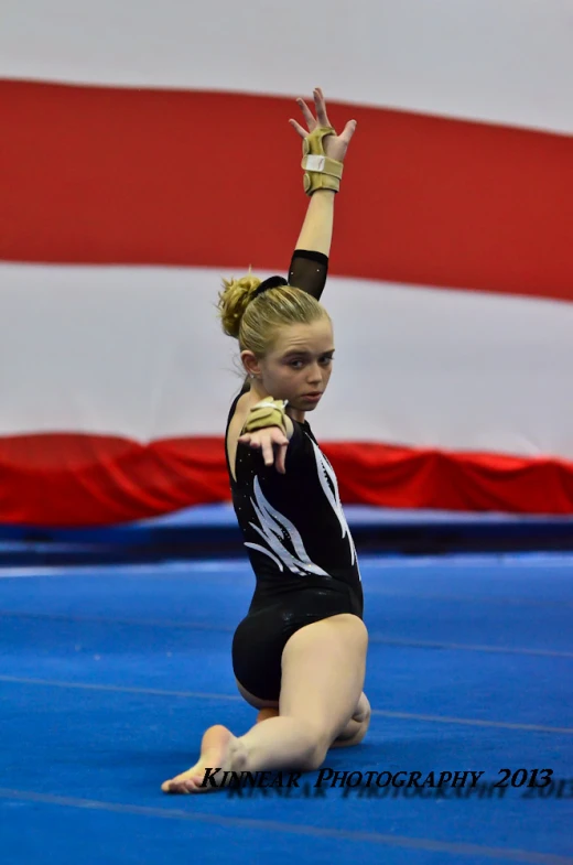 a female cheerleader standing on one leg holding her arms up in the air