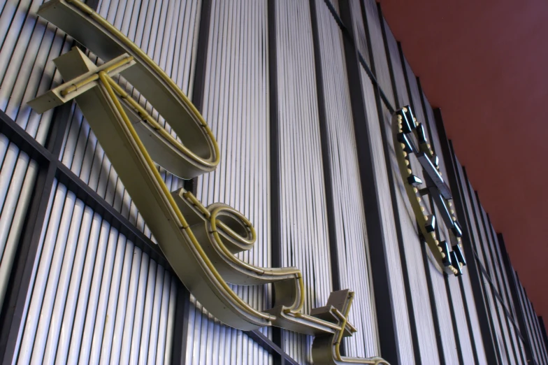 an unusual wall clock with a large metal arrow on it