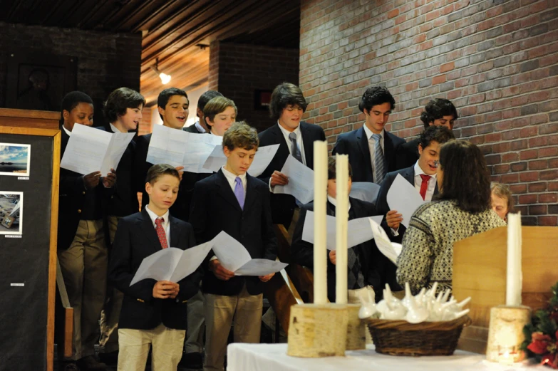 a group of young men singing at a ceremony