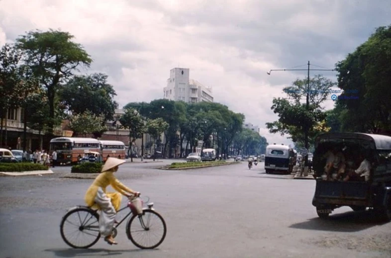 a person in yellow jacket riding bike in street with traffic