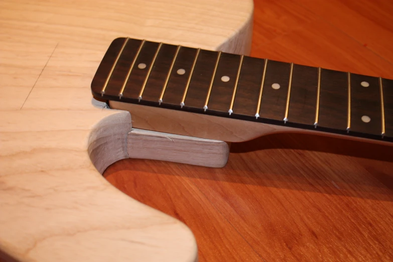 an acoustic guitar sitting on top of a wooden surface