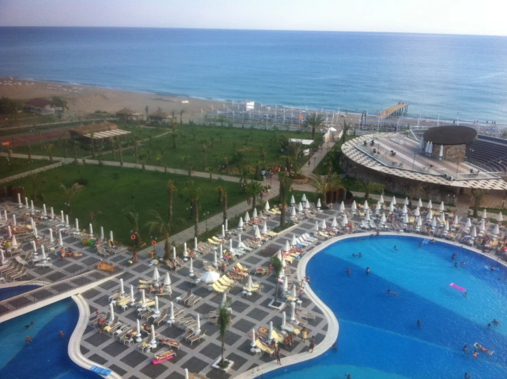 a large pool next to a beach on an ocean shore