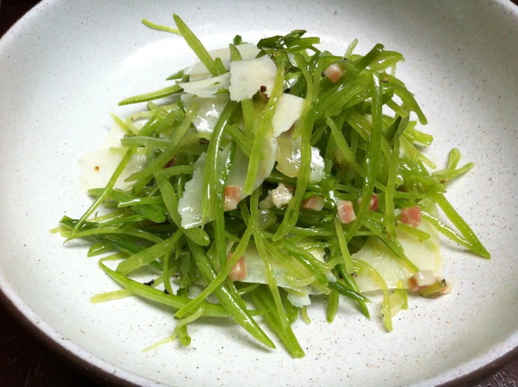 a bowl full of green vegetables on top of a table