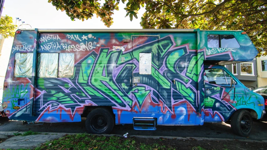 the delivery truck with the graffiti is parked in the driveway