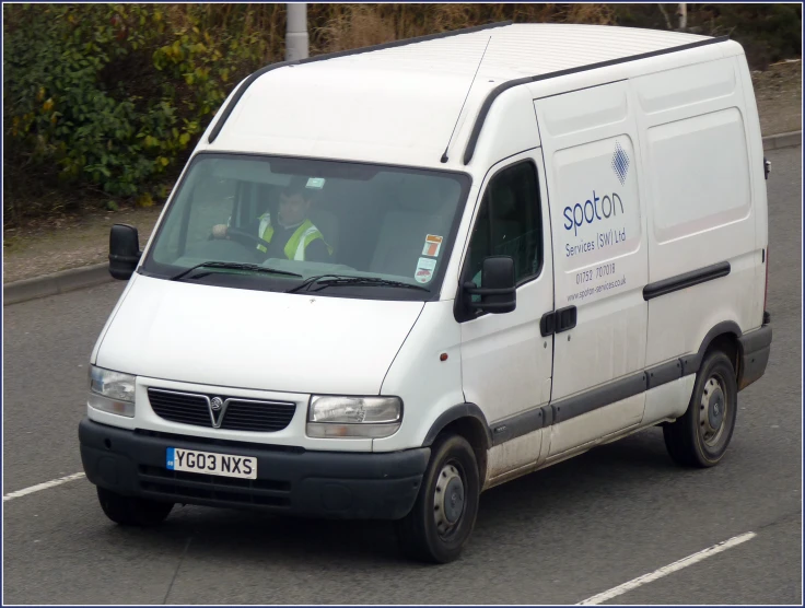 the large white van is parked on the side of the street