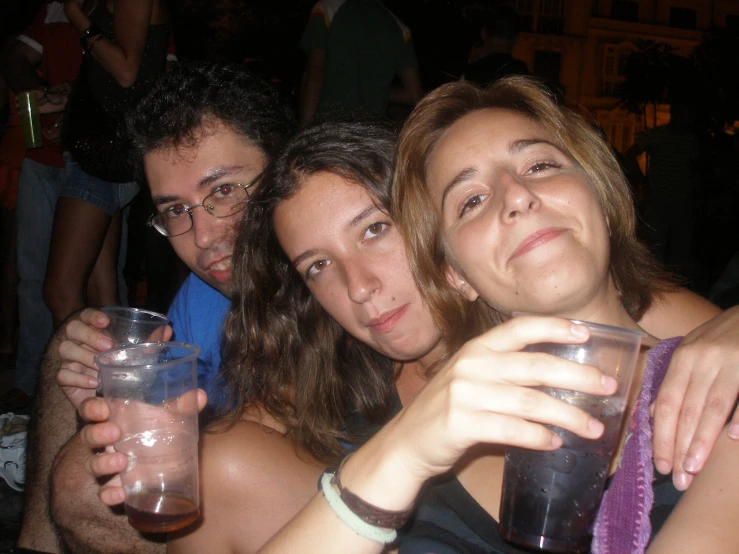 a group of people pose with drinks in their hands