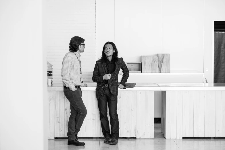 a man and woman are standing in an empty kitchen