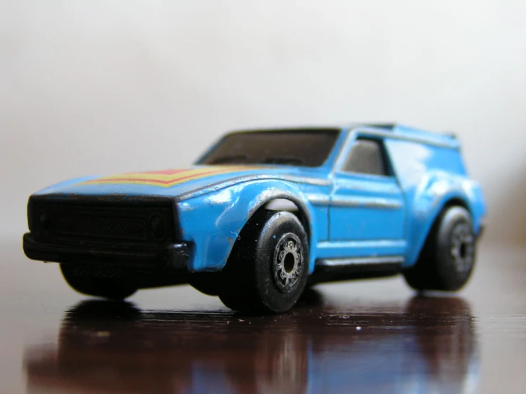 a blue toy car sitting on top of a wooden table