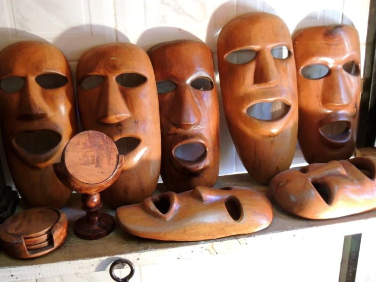a wall with several wooden masks of different shapes and sizes