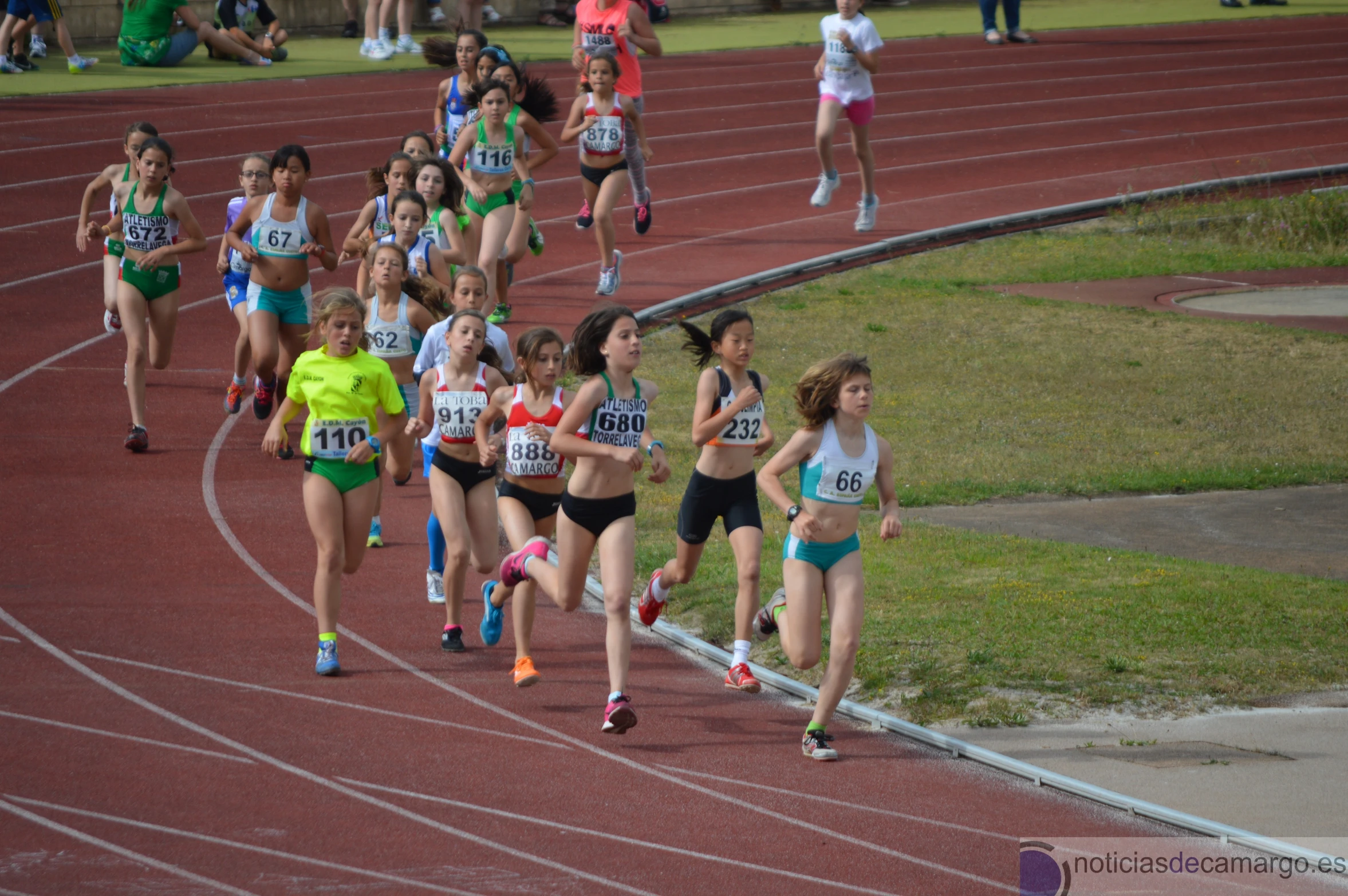 several female athletes running on a race track