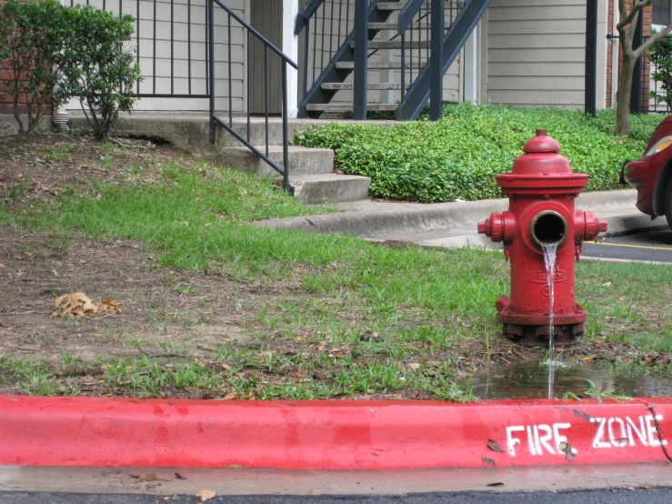 a red fire hydrant in a driveway area next to stairs