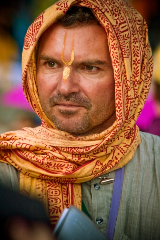 man wearing a colorful scarf and gold metal nose ring