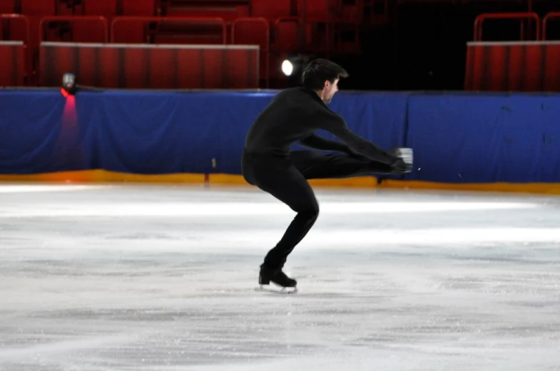 man skating on ice at indoor rink during daytime