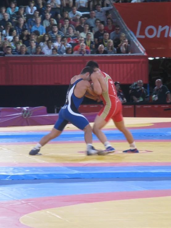 a wrestler bends down to wrestle a wrestling opponent