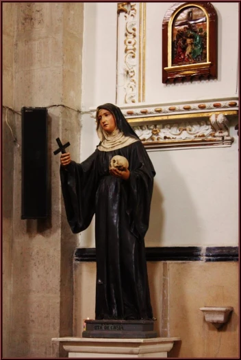there is a statue of the nun holding a skull and a cross