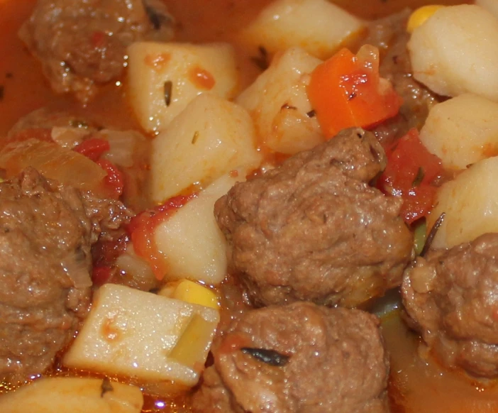 a bowl full of some meat and vegetables with sauce