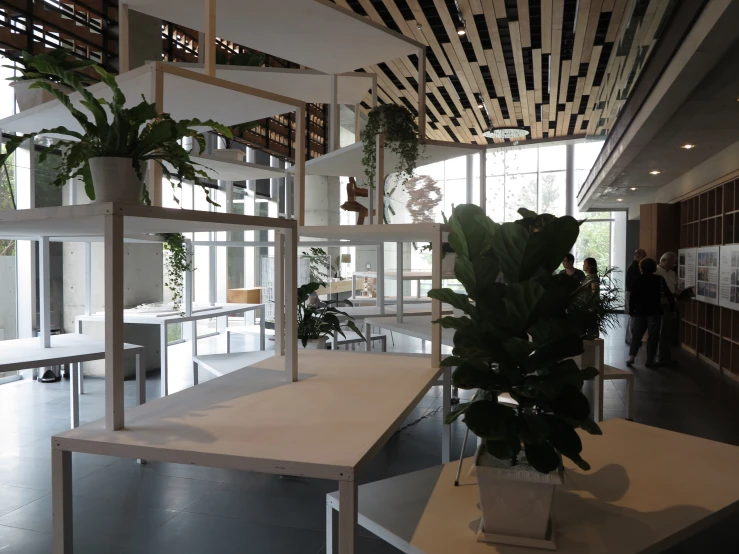 a room with wooden beams and tables and plants