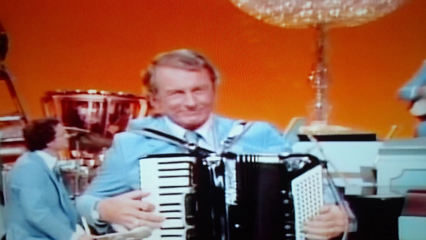 the two men are playing the accordion together