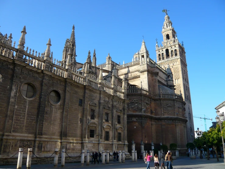 several people walking down the walkway near many ornate buildings