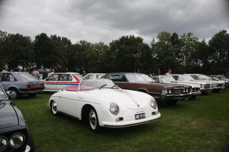 a row of cars sitting on top of a lush green field