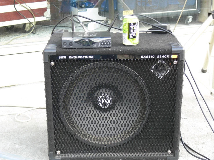 a black amp with a can of coke and a power strip
