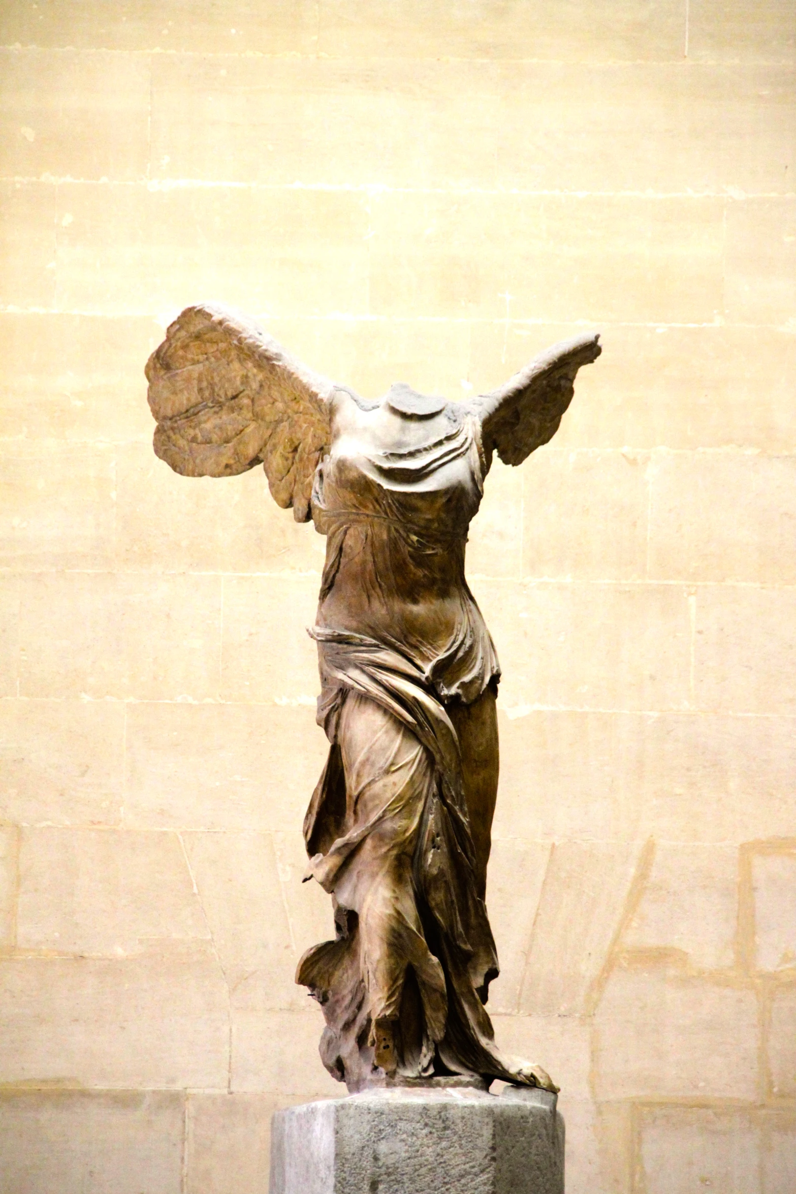 a statue of an angel standing on a pedestal in front of a building