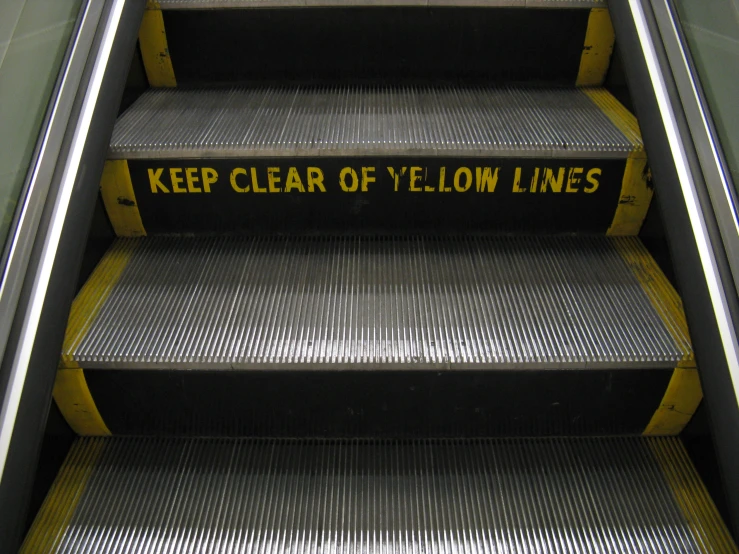 yellow caution stairs sign with words keep clear of yellow lines