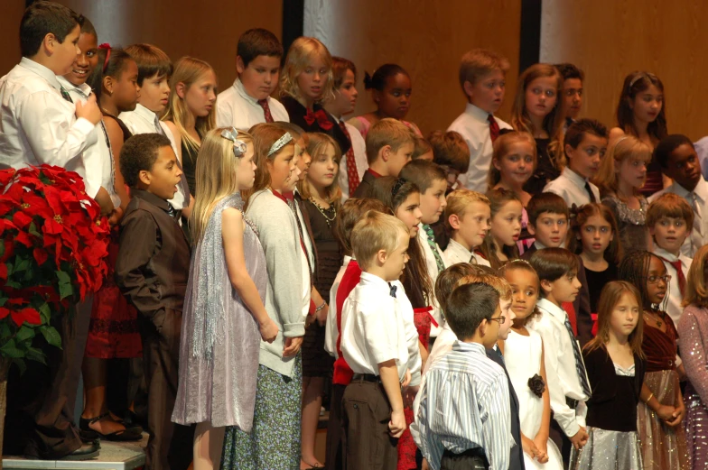 an auditorium with young children standing and singing