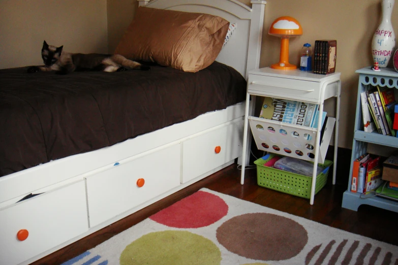 a bed with three drawers under a white bed