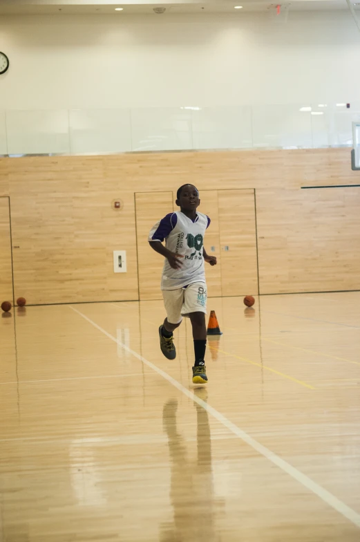 a male tennis player runs and looks at the ball in the air