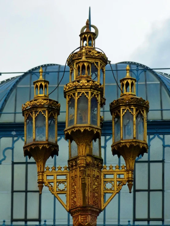 four light ss lamps on a pole against the outside wall