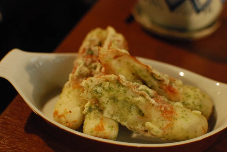 some food in a white bowl sitting on a table