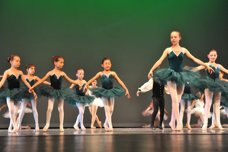 ballet students with green tutus at the end of a performance