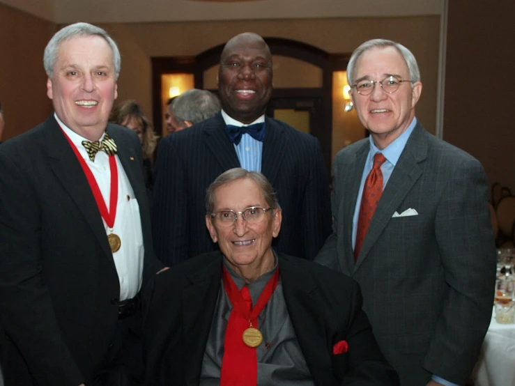 several people who are standing around with medals on their necks