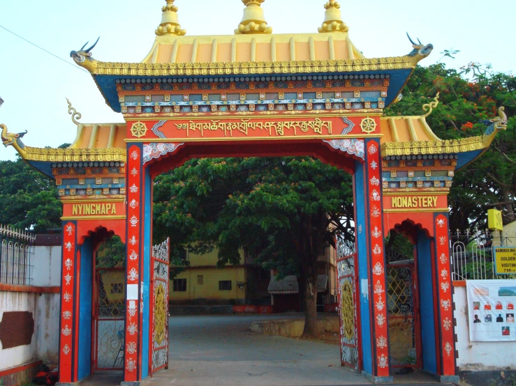 a red gate with golden statues on top of it