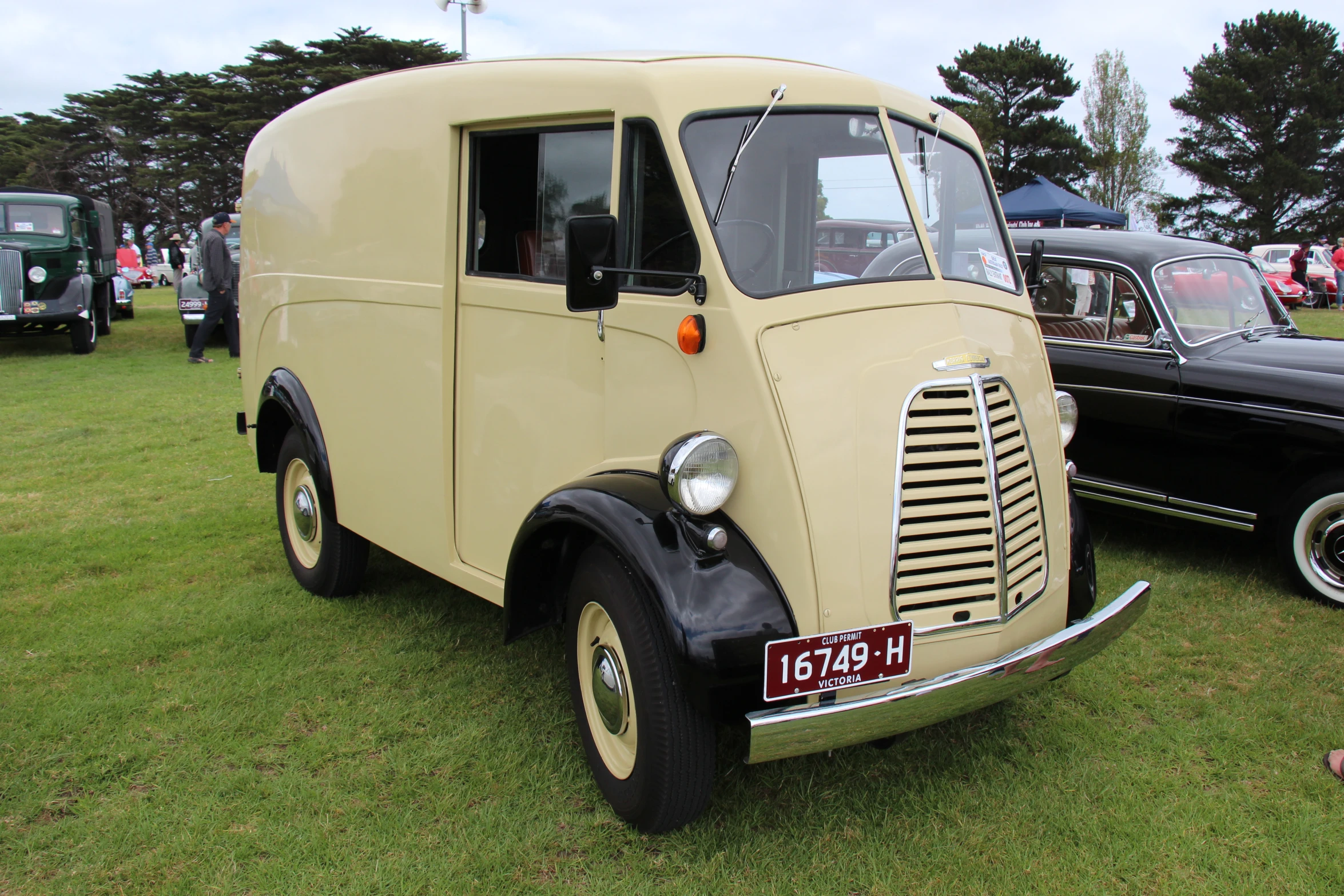 an old cream truck is parked on the grass