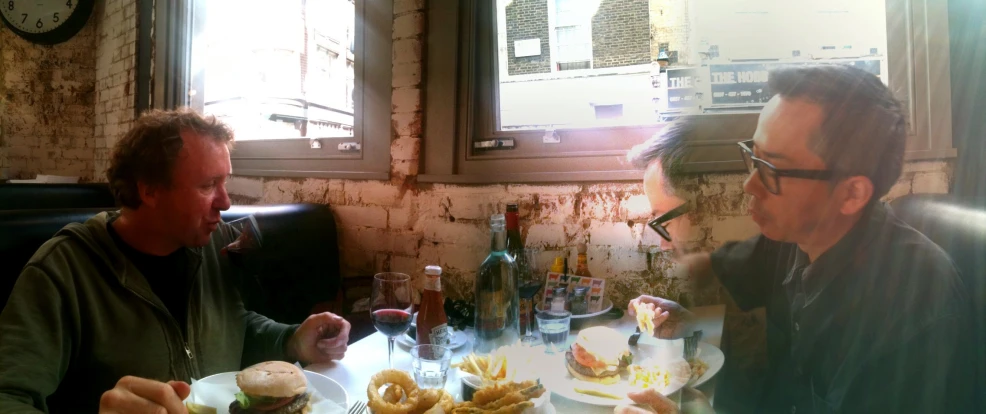 the two men are sharing their meal in a restaurant